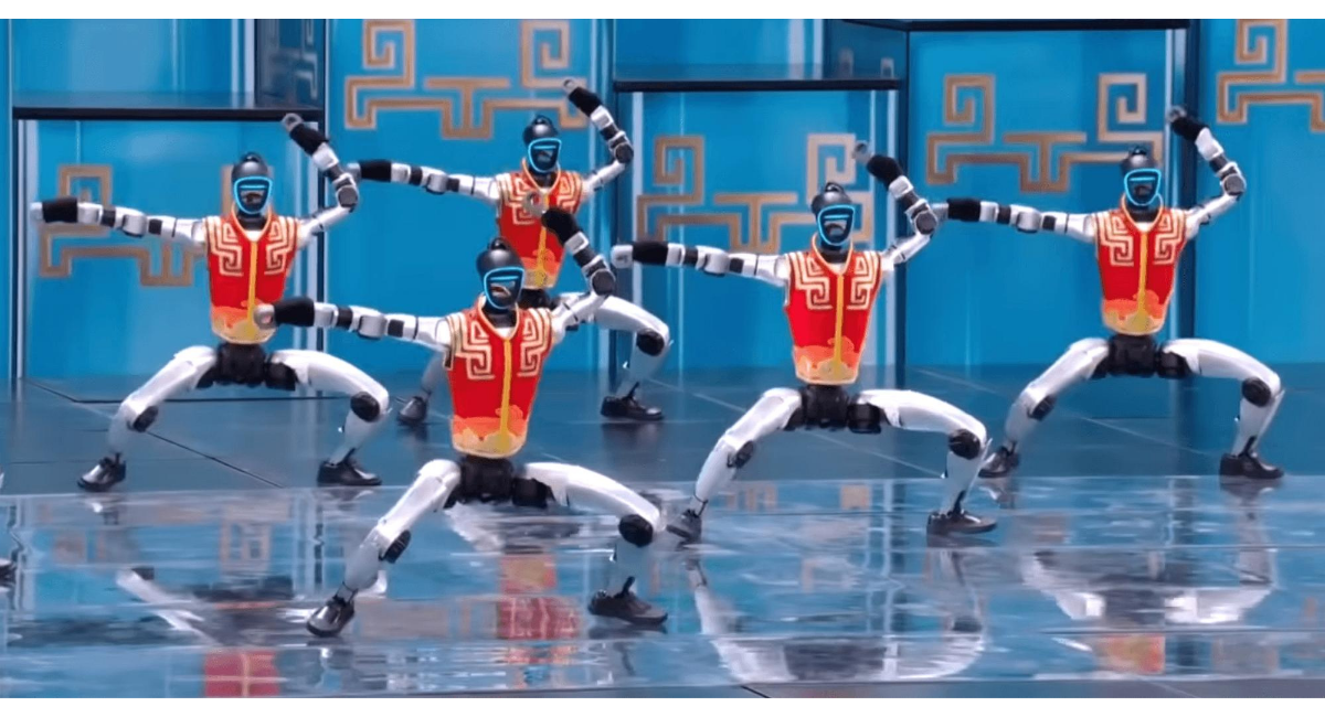 ステージ上で複数の人型ロボットが同時にポーズを取り、シンクロしたダンスパフォーマンスを披露している様子。